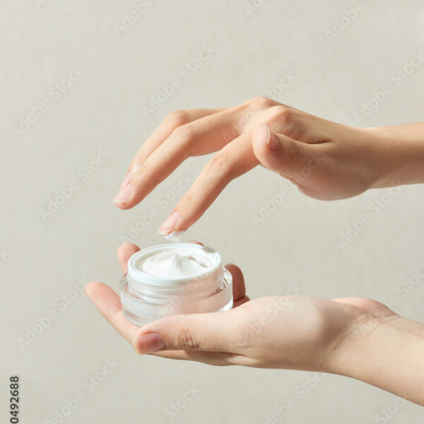 Closeup the hands of a beautiful woman using a nourishing cream jar in her hand.